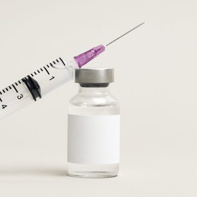 Blank white label on injection bottle glass vial with syringe